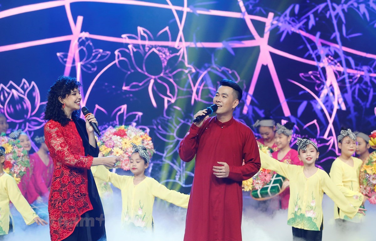 La joven sudafricana Alushka Linh y el cantante vietnamita Ho Trung Dung cantan una canción sobre el Tet en el oeste de Vietnam. (Foto: VTV)