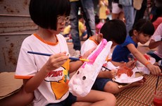 Interesados niños en elaborar máscaras para Festival del Medio Otoño