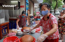 Dueños de tiendas y clientes en Hanoi emocionados en primer día de reapertura de servicios