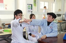 Médico japonés Iizuka Kazuhiro con pacientes vietnamitas en Thanh Hoa 