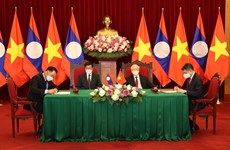 Máximos dirigentes de Vietnam y Laos asisten a firma de documentos de cooperación bilateral 